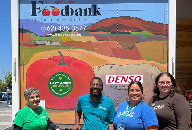 4 people standing in front of a foodbank of socal sign