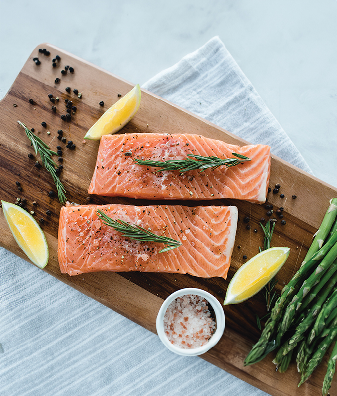 salmon filets and lemon on a wooden cutting board